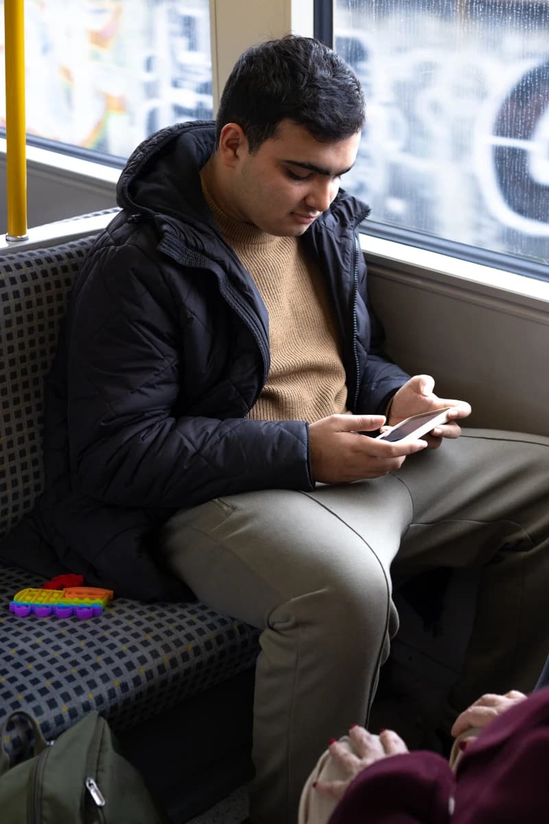 Service user on a train playing on phone